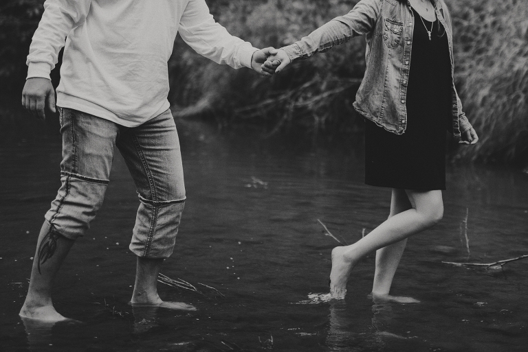 black and white close up of woman leading man into edmonton creek