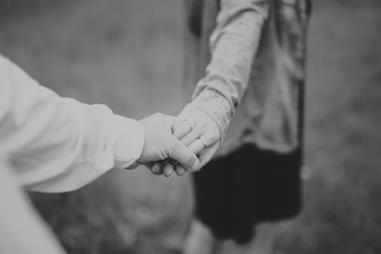 woman leads man by the hand in black and white